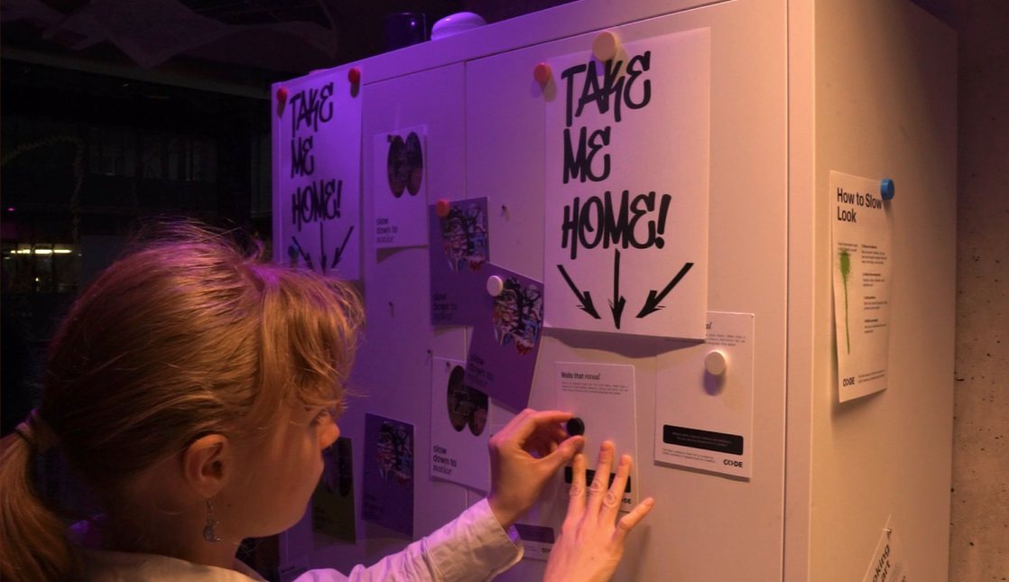 A visitor interacting with the installation's 'Take me home' board