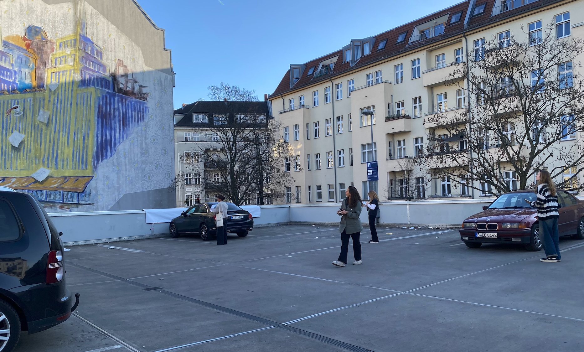 The team standing in a car park looking at a large mural for a slow looking session
